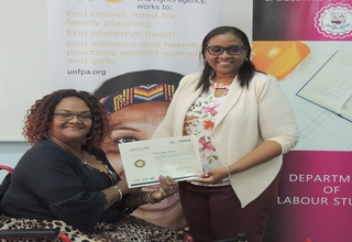 Photo of Charlene Ford being presented with a certificate by Michele Dunn, Programme Assistant in the UNFPA Trinidad Office