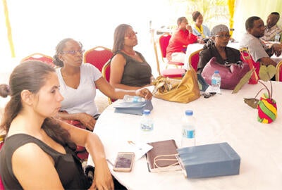 Guests listen attentively during the launch and open day of Groots on Friday at Niles Street, Tunapuna. PHOTOS: ABRAHAM DIAZ