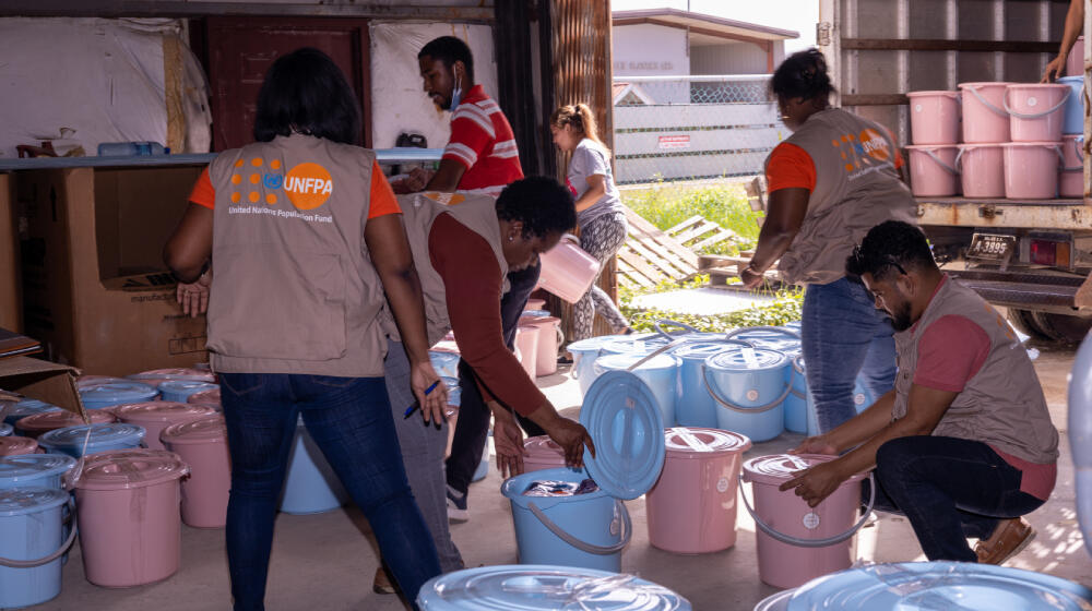 Persons helping to package dignity kits