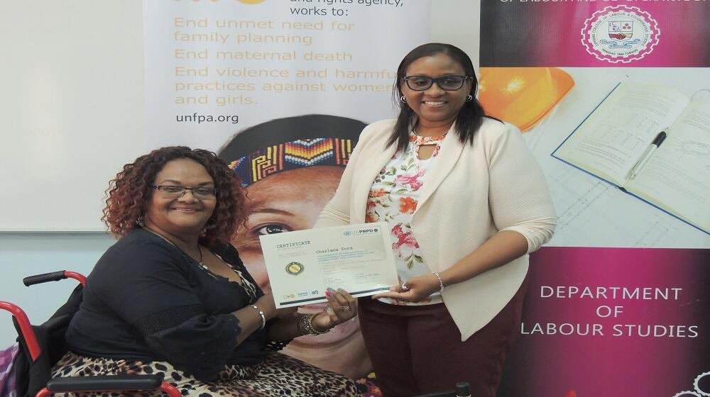 Photo of Charlene Ford being presented with a certificate by Michele Dunn, Programme Assistant in the UNFPA Trinidad Office